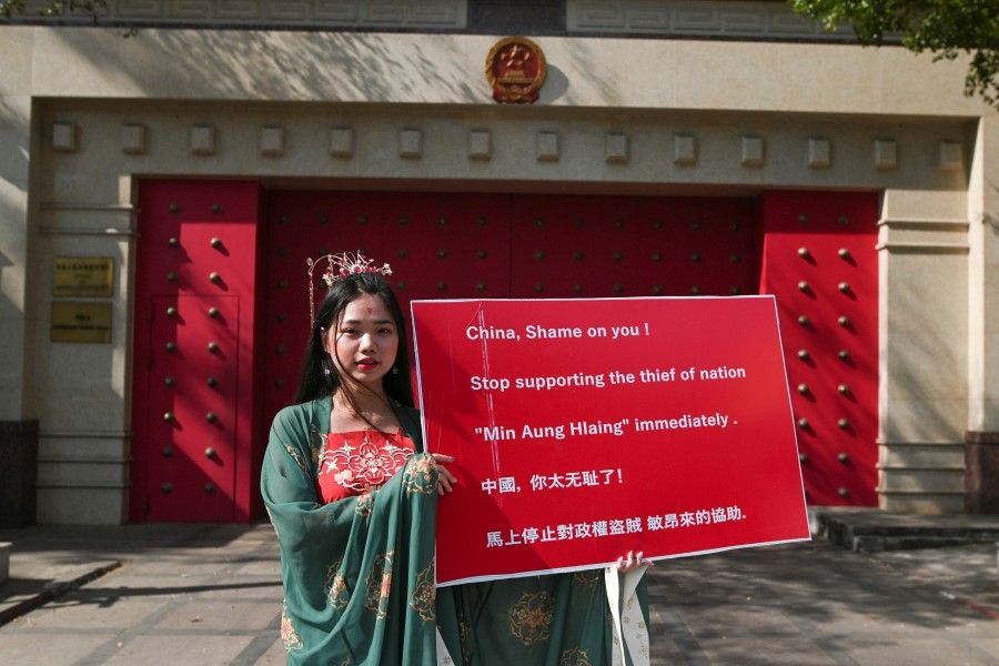 A demonstrator holds a placard while protesting in front of the Chinese embassy, against the military coup and to demand for the release of elected leader Aung San Suu Kyi, in Yangon, Myanmar, 12 February 2021. (Stringer/Reuters)