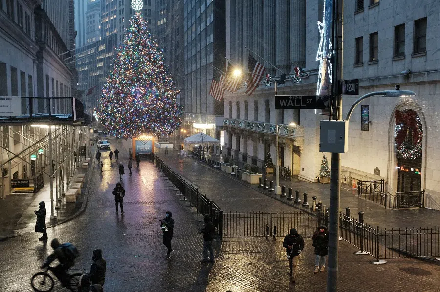 People walk through the blowing snow along Wall Street on 16 December 2020 in New York City, US. (Spencer Platt/Getty Images/AFP)