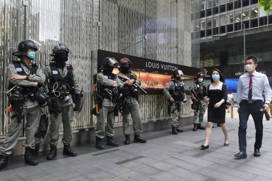 Riot police stand in front of a Louis Vuitton luxury goods store in the Central district in Hong Kong, 28 May 2020. (Roy Liu/Bloomberg)