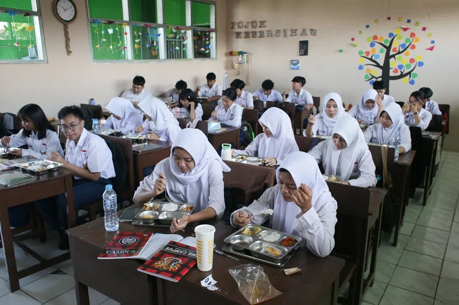 Students eat lunch on the first day of a free-meal programme at PGRI 6 Junior High School in Bogor, West Java, on 6 January 2025. (Aditya Aji/AFP)