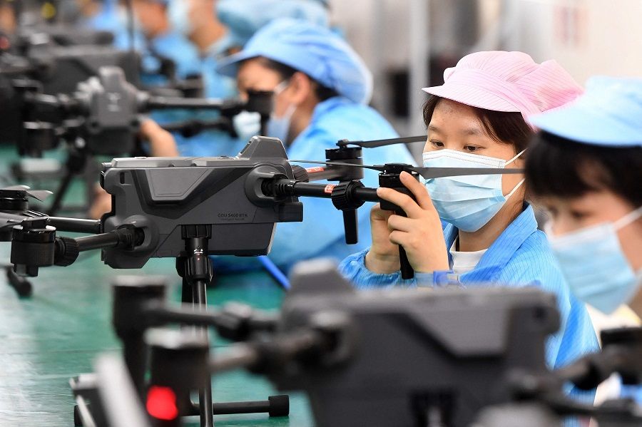 This photo taken on 13 April 2023 shows workers producing drones at a factory in Wuhan, Hubei province, China. (AFP)