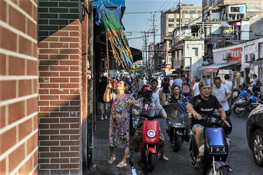 A resident hangs laundry to dry outside of her home in an older neighbourhood in Shanghai, China on 30 August 2021. (Qilai Shen/Bloomberg)