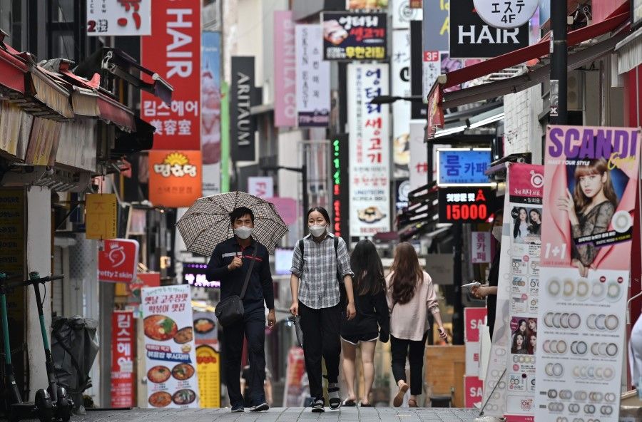 People walk through the Myeongdong shopping district in Seoul on 27 August 2020. (Jung Yeon-je/AFP)
