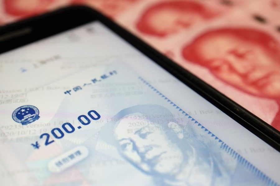 China's official app for digital yuan is seen on a mobile phone next to 100-yuan banknotes in this illustration picture taken 16 October 2020. (Florence Lo/REUTERS)
