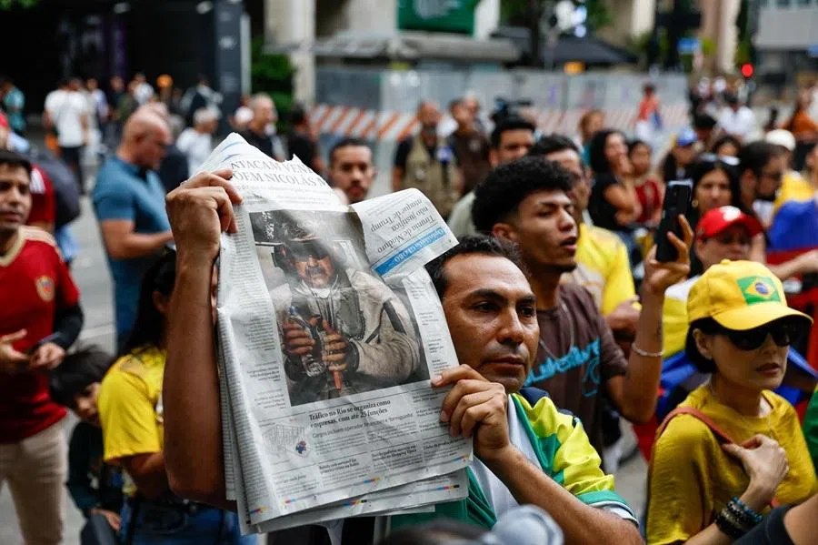 A man holds a newspaper showing a photograph which US President Donald Trump posted on his Truth Social account, and which shows what he described as Venezuelan President "Nicolas Maduro on board the USS Iwo Jima" amphibious assault ship, as Venezuelans and their supporters take part in a demonstration for freedom and a democratic transition, after the US launched strikes on Venezuela, capturing its President Nicolas Maduro and his wife Cilia Flores, at Paulista Avenue in Sao Paulo, Brazil, on 4 January 2026. (Tuane Fernandes/Reuters)