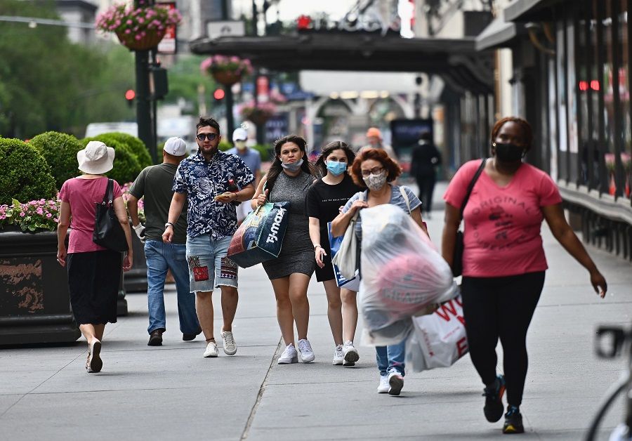 People carry shopping bags as they walk near Herald Square on 25 June 2020 in New York City. (Angela Weiss/AFP)