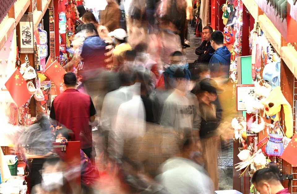 People walk at an alley in Qianmen street in Beijing, China, on 2 October 2022. (Noel Celis/AFP)