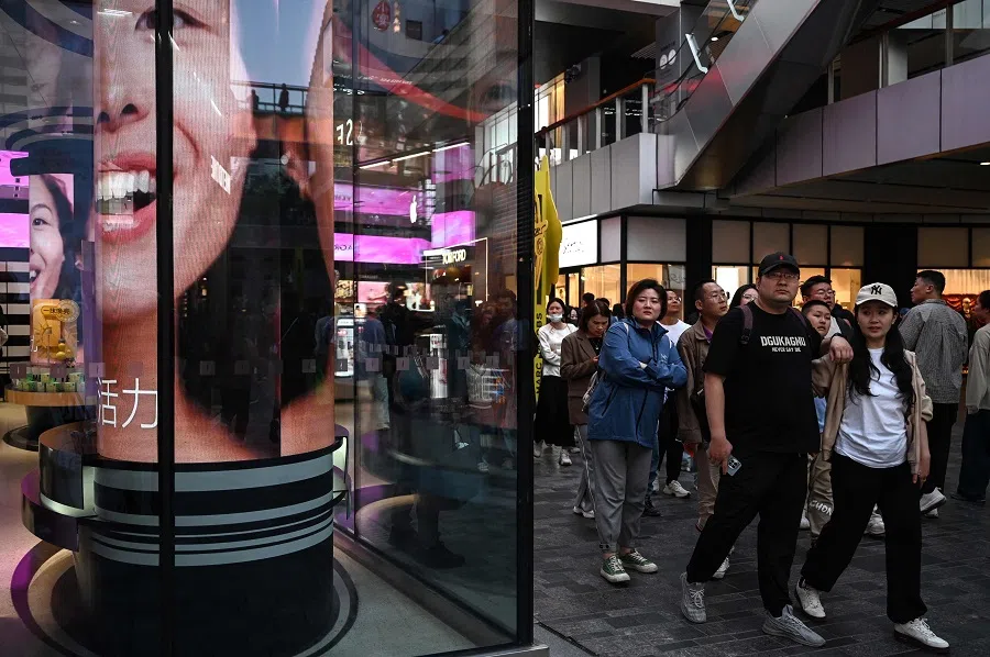 People walk in a shopping mall in Beijing, China, on 4 October 2024. (Greg Baker/AFP)