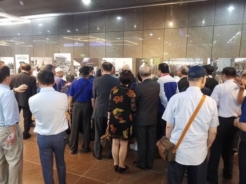 Visitors look at the photos at the exhibition.
