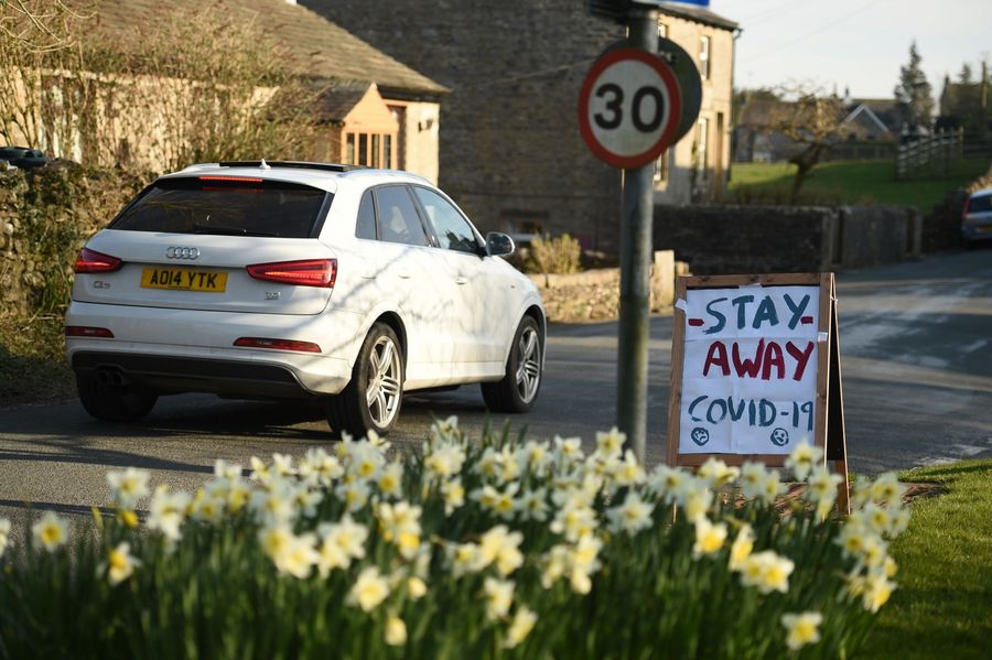 A sign instructing tourists to "Stay Away" is seen beside the road in the village of Airton in northern England on 22 March 2020. (Oli Scarff/AFP)