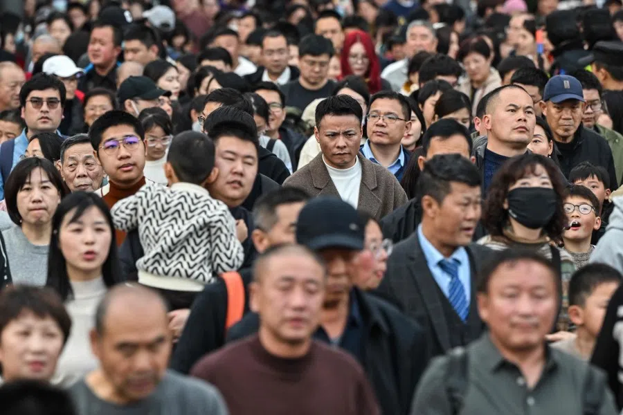People cross a street on the Bund during the fifth day of the Lunar New Year of the Dragon in Shanghai on 14 February 2024. (Hector Retamal/AFP)