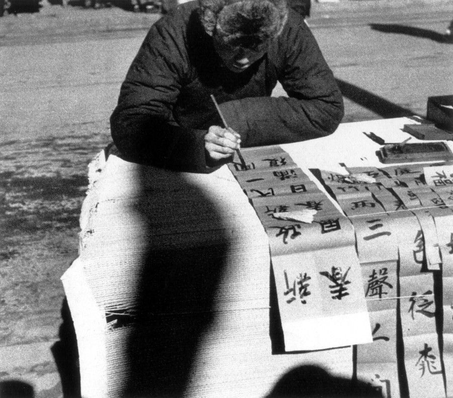 A stall offering handwritten new year wishes at a temple fair in Beijing. There was no printing at the time, and many educated people wrote couplets for extra cash.