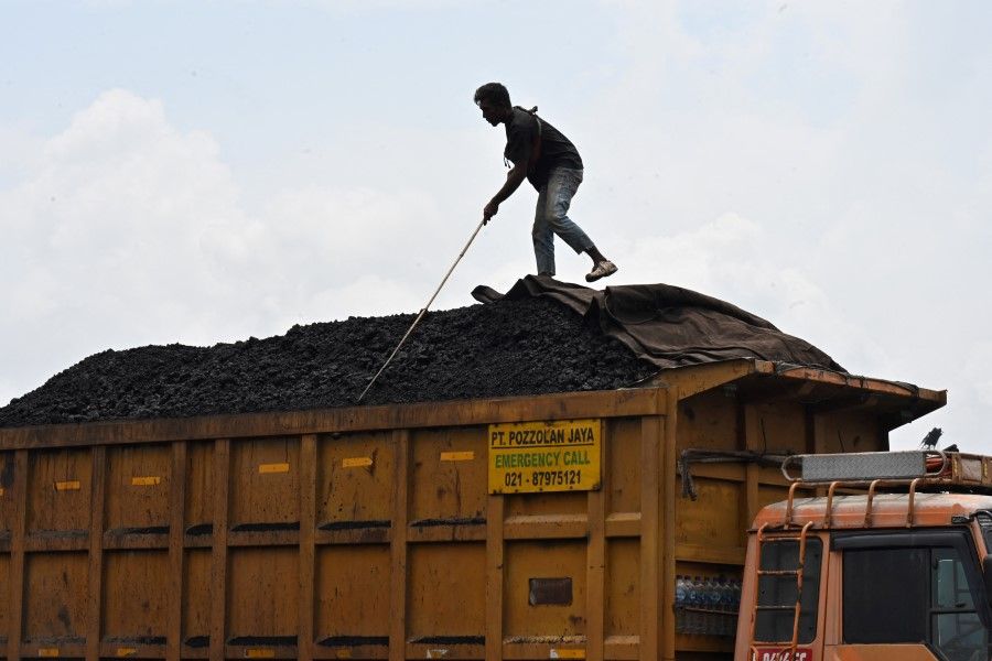 An employee works on a truck filled with coal at the Karya Citra Nusantara (KCN) Marunda port in Jakarta on 17 January 2022, after Indonesia eased an export ban on the commodity. (Adek Berry/AFP)
