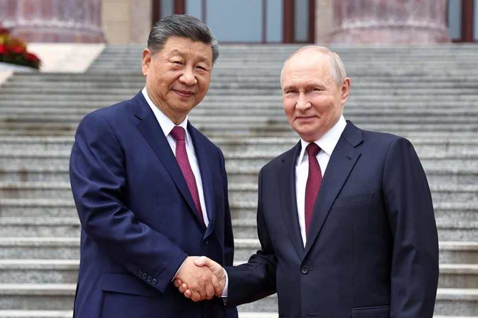 Russian President Vladimir Putin shakes hands with Chinese President Xi Jinping during a welcoming ceremony at the Great Hall of the People in Beijing, China, 20 May 2026. (Sputnik/Alexander Kazakov/Pool via Reuters)