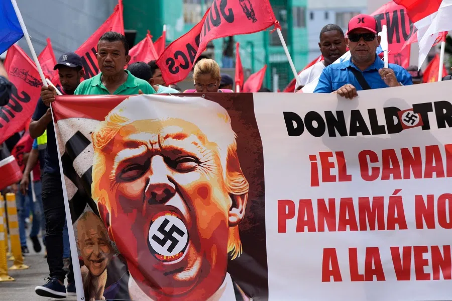 Demonstrators hold a banner reading “The Panama Canal is Not For Sale” with a picture of US President Donald Trump with a swastika during a protest against his inauguration in Panama City outside the residence of the US ambassador in Panama City on 20 January 2025. (Arnulfo Franco/AFP)