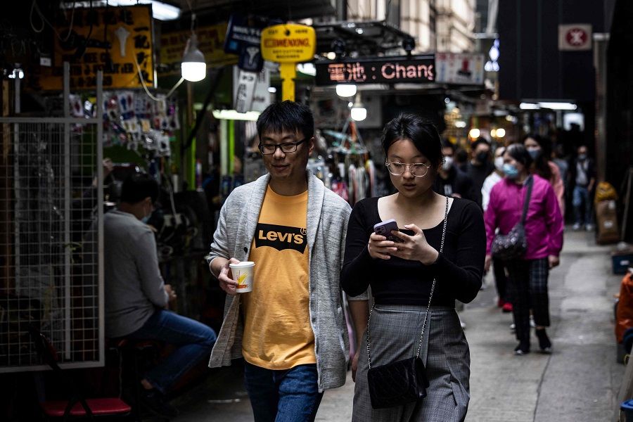 People walk through the central business district in Hong Kong, China, on 1 March 2023. (Isaac Lawrence/AFP)