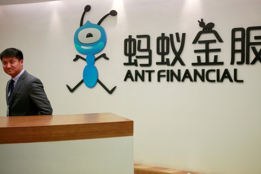 An employee stands next to the logo of Ant Financial Services Group, Alibaba's financial affiliate, at its headquarters in Hangzhou, Zhejiang province, China, 24 January 2018. (Shu Zhang/REUTERS)