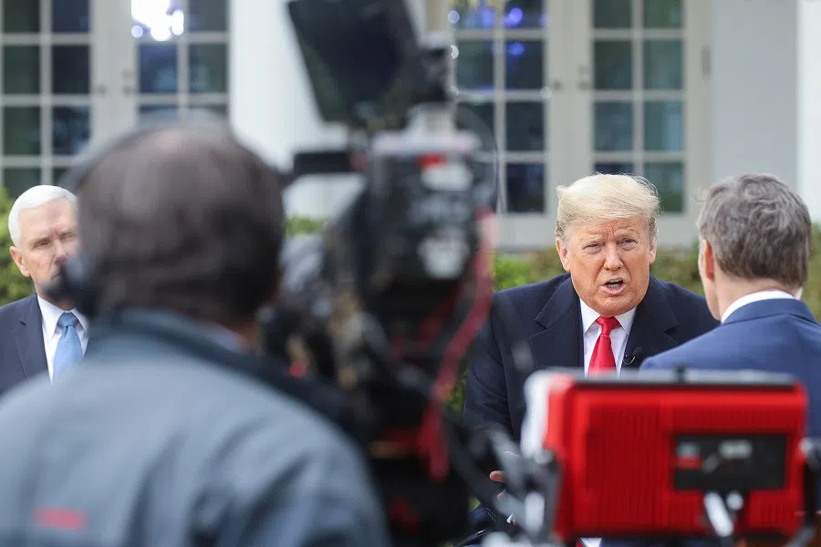 US President Donald Trump speaks during a Fox News “virtual town hall” event on the coronavirus outbreak as Vice-President Mike Pence listens in the Rose Garden of the White House in Washington, US, on 24 March 2020. (Jonathan Ernst/Reuters)