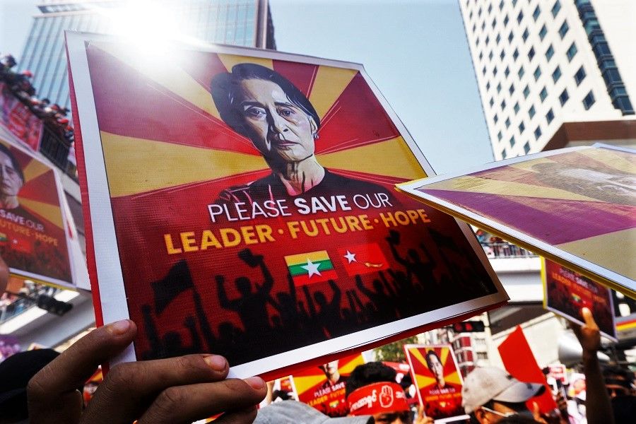 Protesters hold signs with an image of Aung San Suu Kyi as they take part in a demonstration against the military coup in Yangon, Myanmar, on 22 February 2021. (Sai Aung Main/AFP)