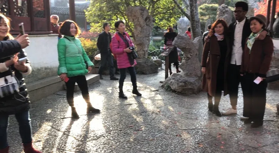 Hasani takes pictures with curious onlookers in China. (Photo provided by Hasani Arnold)