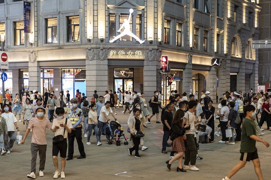 Shoppers and pedestrians walk along Nanjing Road in Shanghai, China on 6 June 2021. (Qilai Shen/Bloomberg)