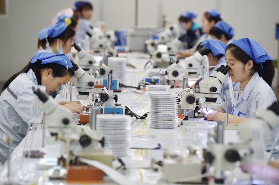 This photo taken on 11 May 2023 shows workers producing electronic components at a factory in Suqian, in China's eastern Jiangsu province. (AFP)