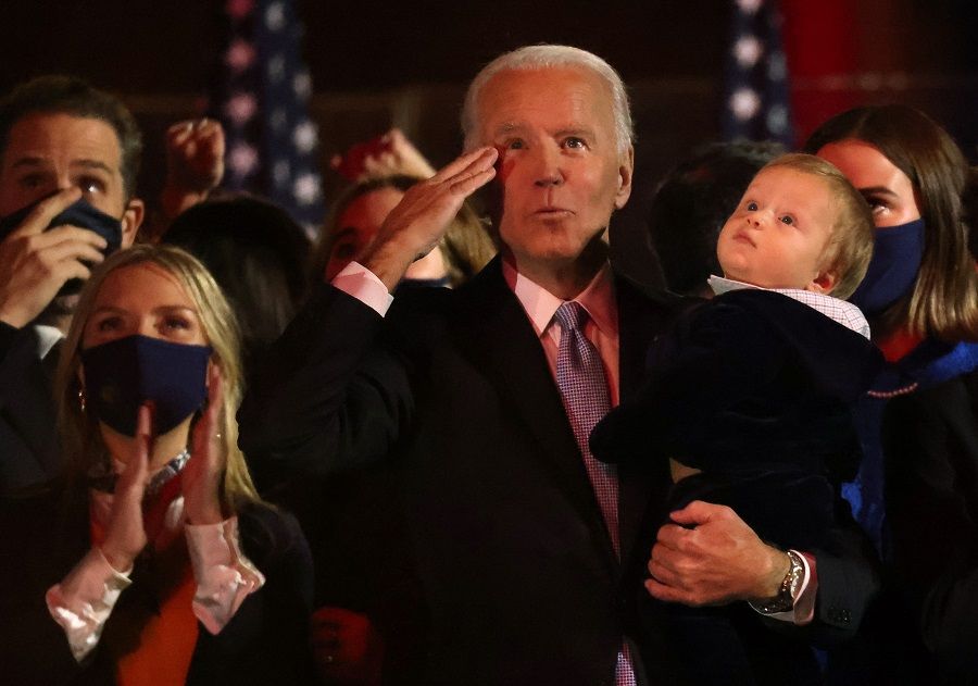 Democratic US presidential nominee Joe Biden gestures as he carries his grandchildren after speaking during his election rally, after news media announced that he has won the 2020 US presidential election, in Wilmington, Delaware, US, 7 November 2020. (Jonathan Ernst/Reuters)