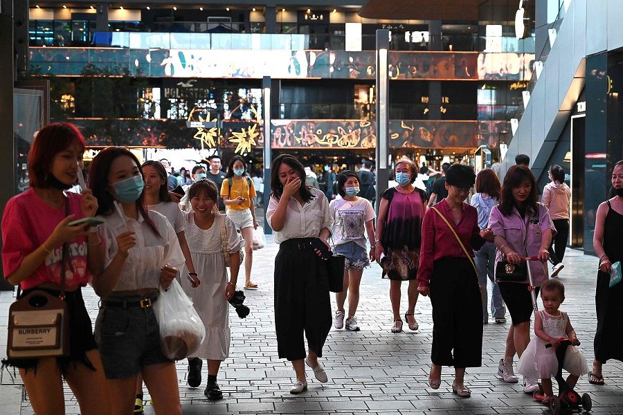 People walk in a shopping mall in Beijing, China on 21 June 2021. (Greg Baker/AFP)