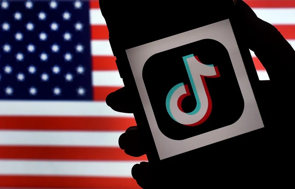 In this photo illustration, the social media application logo, TikTok is displayed on the screen of an iPhone on an American flag background on 3 August 2020 in Arlington, Virginia. (Olivier Douliery/AFP)