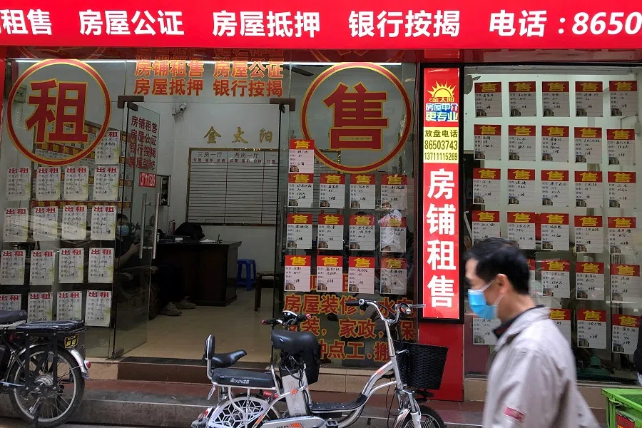 A man wearing a face mask walks past an estate agent in Guangzhou's Sanyuanli area, in Guangdong province, China, 13 April 2020. (David Kirton/File Photo/Reuters)