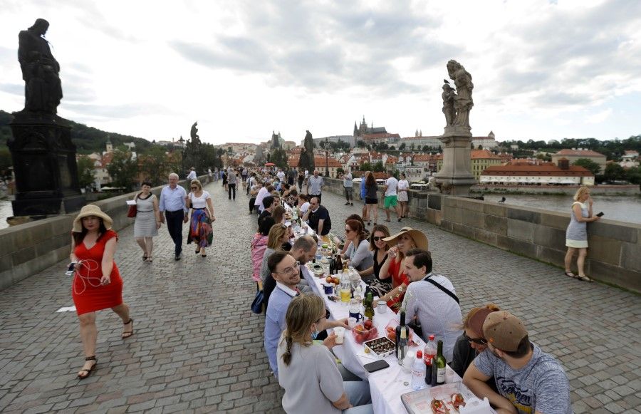 Residents dine at a 500-metre-long table spanning across the length of the medieval Charles Bridge as restrictions ease following the coronavirus disease (COVID-19) outbreak, in Prague, Czech Republic, 30 June 2020. (David W Cerny/REUTERS)