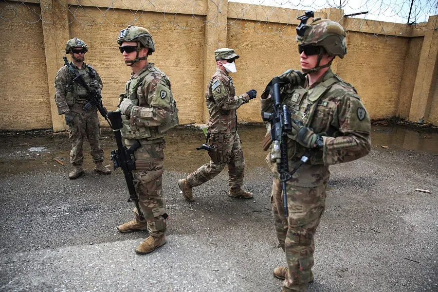 US army soldiers, part of the Combined Joint Task Force - Operation Inherent Resolve (CJTF-OIR), the US-led coalition against the Islamic State (IS) group, stand on duty at the K1 airbase northwest of Kirkuk in Iraq on 29 March 2020. (Ahmad Al-Rubaye/AFP)