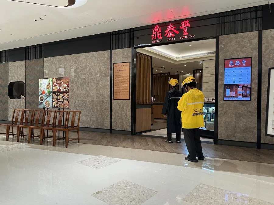 Delivery riders wait outside a Din Tai Fung restaurant.