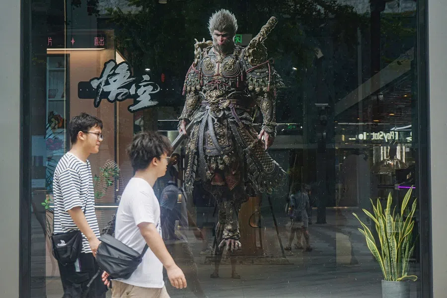 People walk past the image of the Monkey King character, or Sun Wukong, of Chinese action role-playing game Black Myth: Wukong, developed by Chinese video game company Game Science, during its launch day in Hangzhou, Zhejiang province, China, on 20 August 2024.