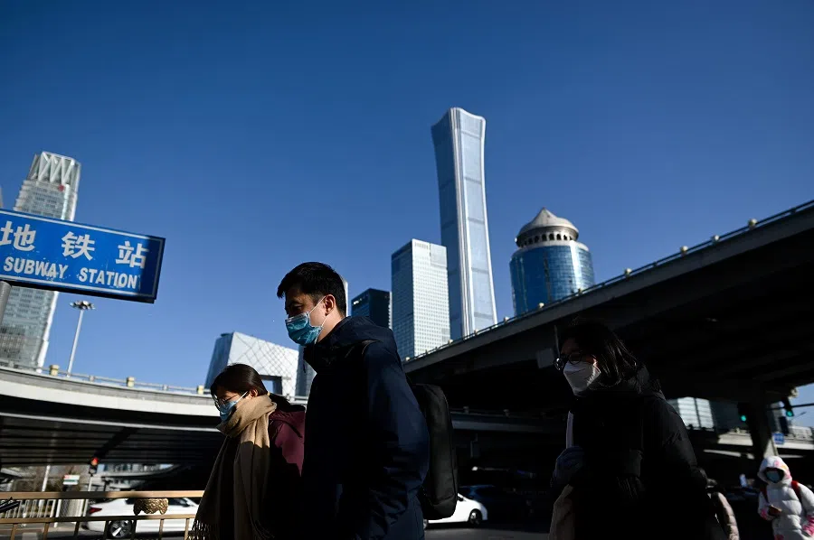 Pedestrians walk in the central business district of Beijing on 18 January 2021. (Wang Zhao / AFP)