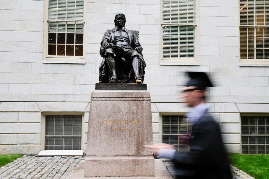 A student walks past the statue of John Harvard on the day of the 374th Commencement exercises at Harvard University in Cambridge, Massachusetts, US, on 29 May 2025. (Brian Snyder/Reuters)