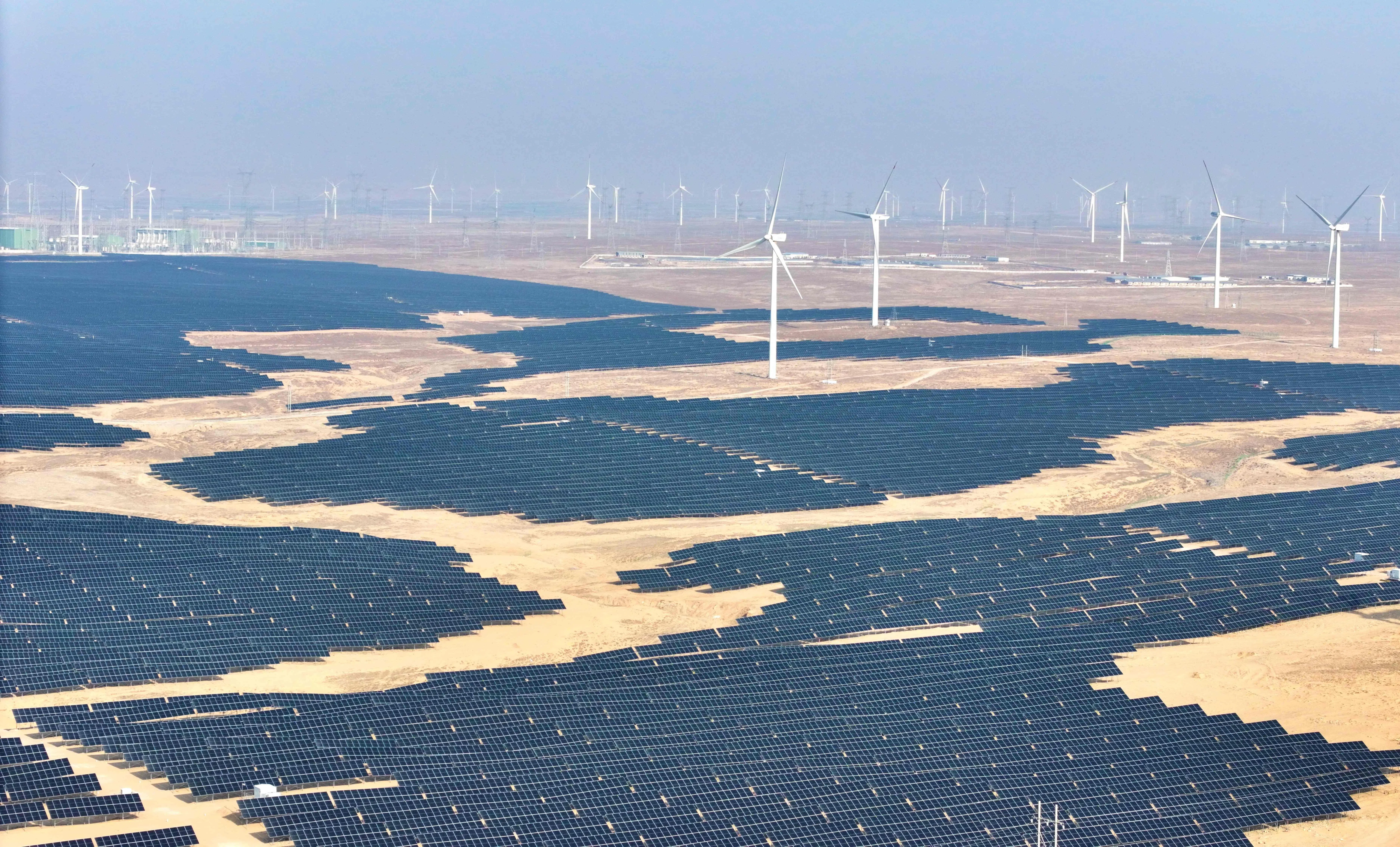 This picture taken on 22 December 2025 shows solar panels and wind turbines at a renewable energy farm in Lingwu, Ningxia region, China.