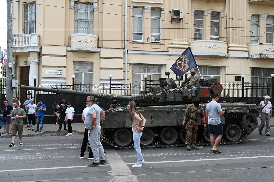 People gather in a street as fighters of Wagner private mercenary group are deployed near the headquarters of the Southern Military District in the city of Rostov-on-Don, Russia, on 24 June 2023. (Stringer/Reuters)