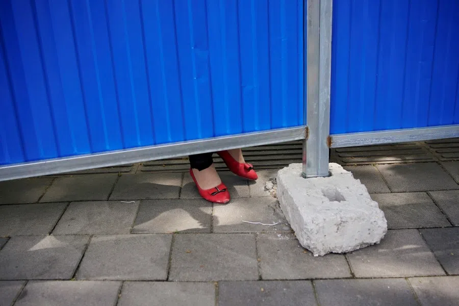 A resident's feet are seen behind a barricade fencing a residential compound after the lockdown against the coronavirus disease (COVID-19) was lifted in Wuhan, Hubei province, China, 14 April 2020. (Aly Song/Reuters)