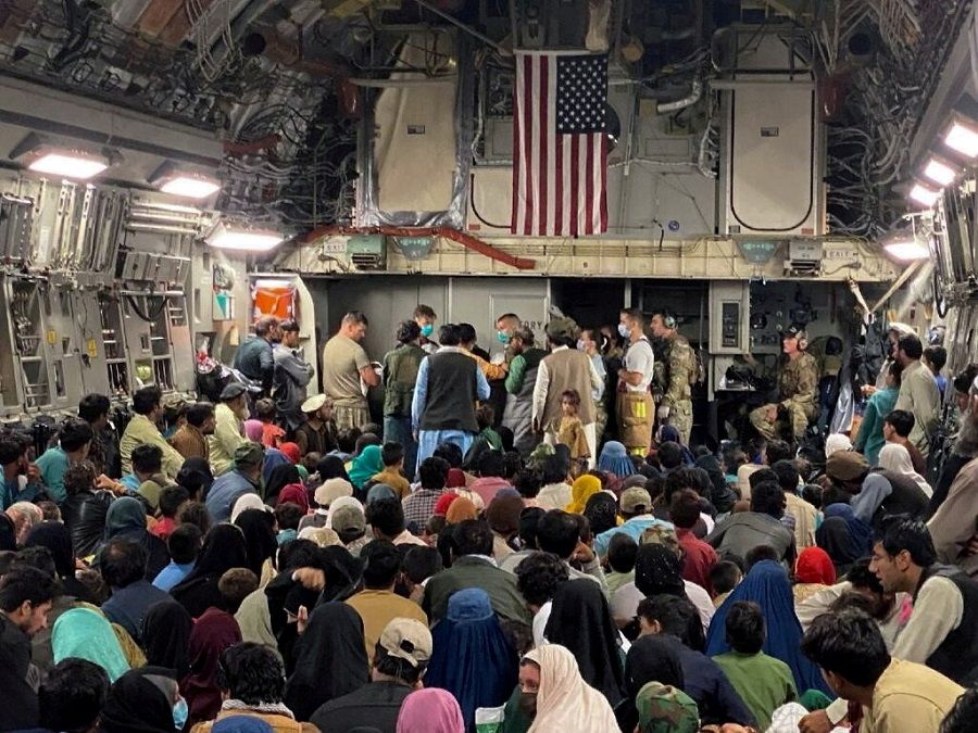A newborn baby is looked after prior to taking off with other Afghan evacuees on a C-17 Globemaster III at a Middle East staging area, 23 August 2021. (US Air Force//Handout via Reuters)