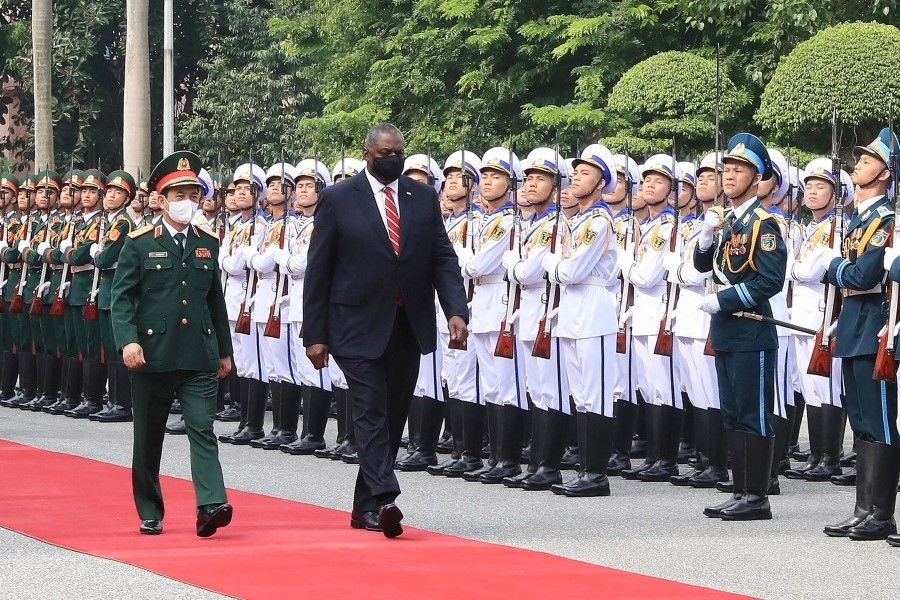 This picture taken and released by the Vietnam News Agency on 29 July 2021 shows US Secretary of Defence Lloyd Austin (centre) inspecting a guard of honour along with Vietnam's Defence Minister Phan Van Giang (left) during a welcoming ceremony in Hanoi. (STR/Vietnam News Agency/AFP)