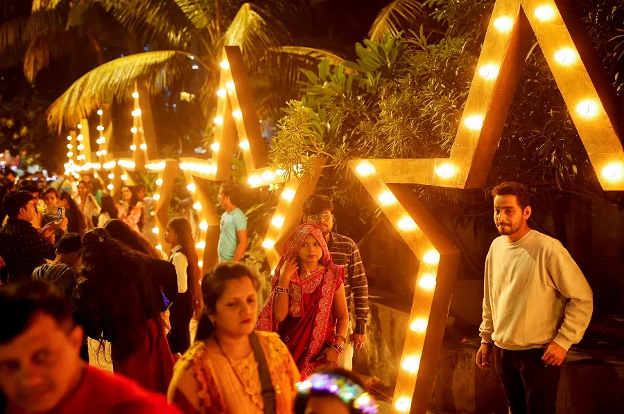 People walk next to installations at a promenade in Mumbai, India, on 31 December 2023. (Francis Mascarenhas/Reuters)