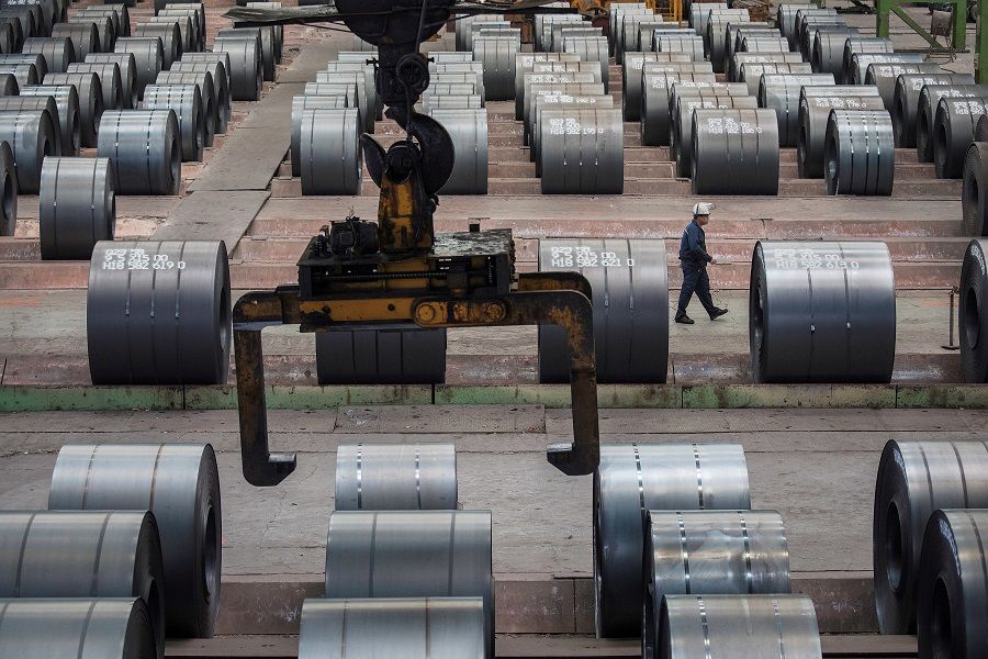 In this file photo taken on 6 August 2018, a worker walks past steel rolls at the Chongqing Iron and Steel plant in Changshou, Chongqing, China. (Damir Sagolj/File Photo/Reuters)