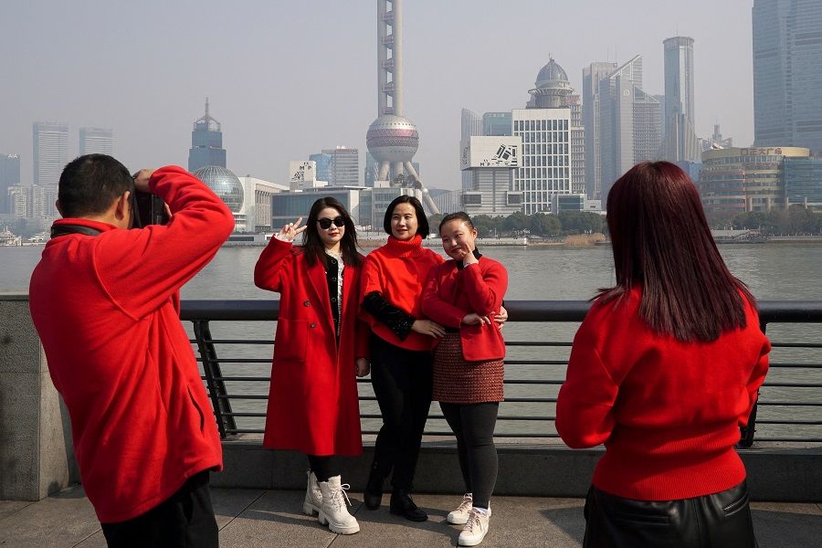 Women pose for pictures on the Bund in front of Shanghai's skyline, on the first day of the Lunar New Year of the Dragon, in Shanghai, China, on 10 February 2024. (Nicoco Chan/Reuters)