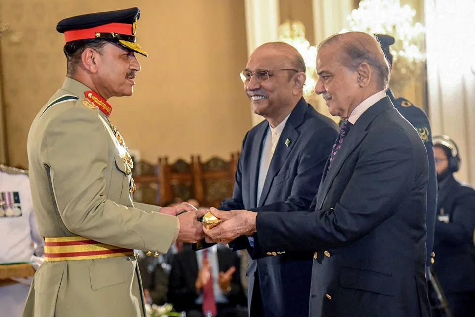 This handout photograph taken and released on 22 May 2025 by the Pakistan's Press Information Department shows Pakistan's Prime Minister Shehbaz Sharif (R) and President Asif Ali Zardari (C) jointly conferring the Baton of Field Marshal on Chief of Army Staff General Syed Asim Munir during a ceremony at the country's President House in Islamabad. (Pakistan’s Press Information Department/AFP)