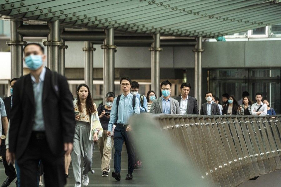 Pedestrians on a footbridge in Hong Kong, China, on 24 April 2023. (Lam Yik/Bloomberg)