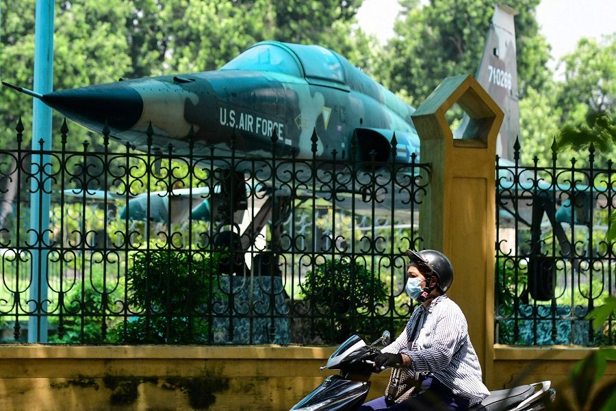A motorist rides past a US aircraft displayed in the Vietnam Military History Museum in Hanoi, Vietnam, on 25 August 2021. (Nhac Nguyen/AFP)