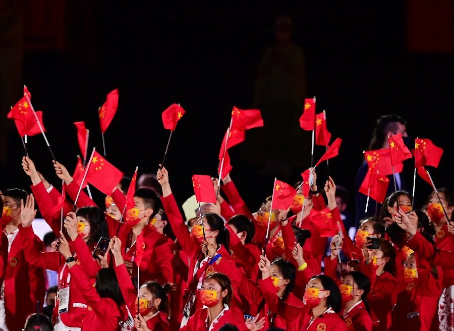 Members of China's delegation wave flags as they enter the Olympic Stadium during the opening ceremony of the Tokyo 2020 Olympic Games, in Tokyo, Japan, on 23 July 2021. (Franck Fife/AFP)