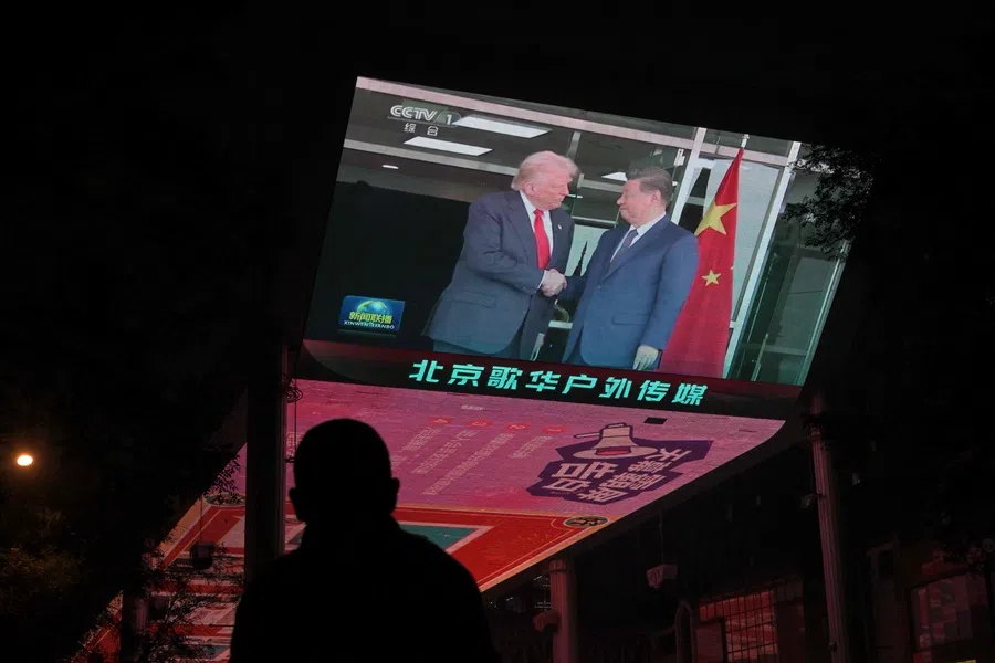 A screen shows news coverage of the meeting between US President Donald Trump and China's President Xi Jinping in South Korea, outside a shopping mall in Beijing on 30 October 2025.