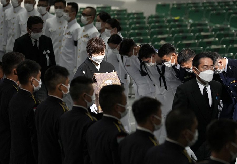 Honour guards bow to Akie Abe (centre), widow of Japan's former prime minister Shinzo Abe, as she leaves with the cinerary urn containing his ashes behind Japan's Prime Minister Fumio Kishida (right) at the end of Abe's state funeral at the Nippon Budokan in Tokyo, Japan, on 27 September 2022. (Franck Robichon/Pool/AFP)